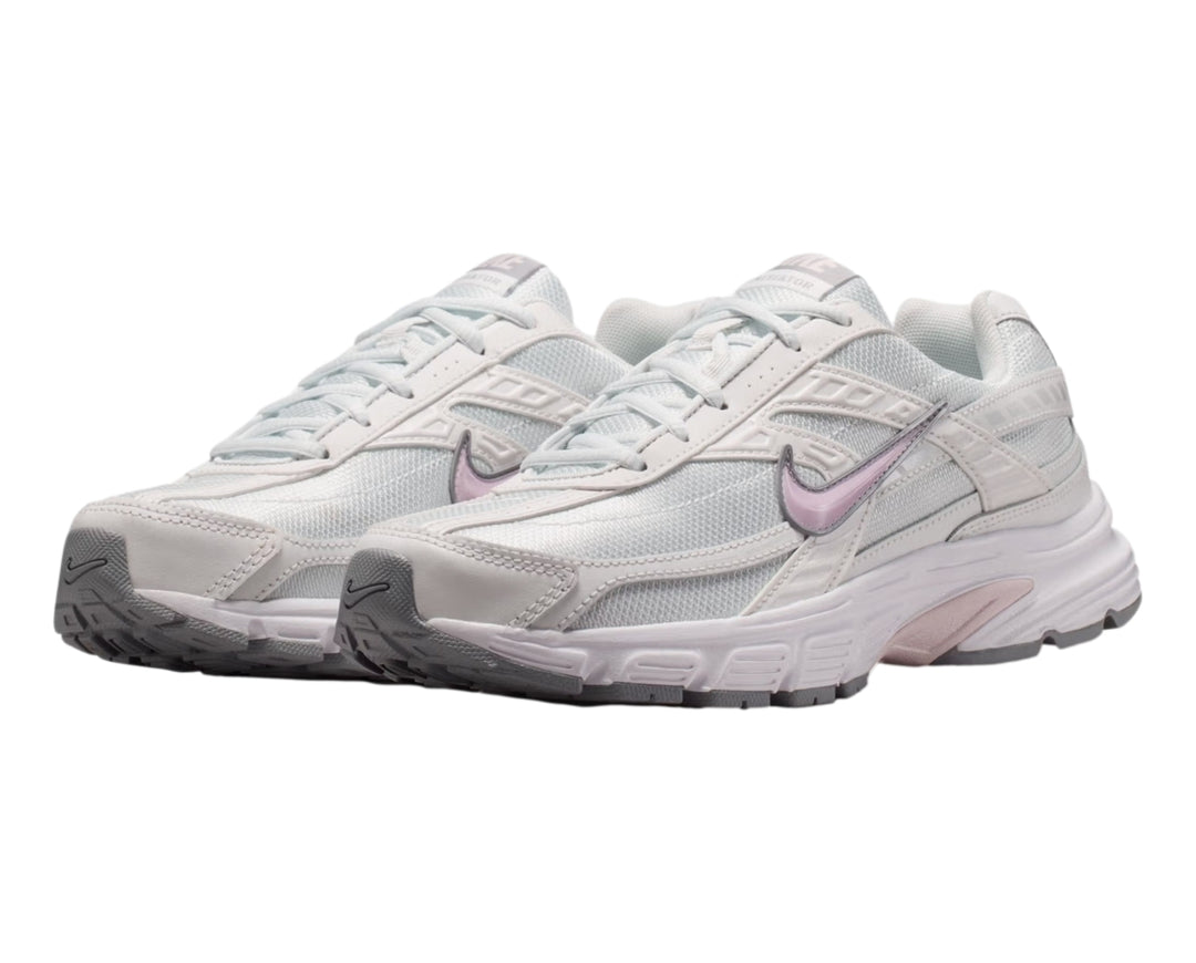 Tenis Nike Initiator blancos con detalles en color lila y suela gris, vista lateral.
