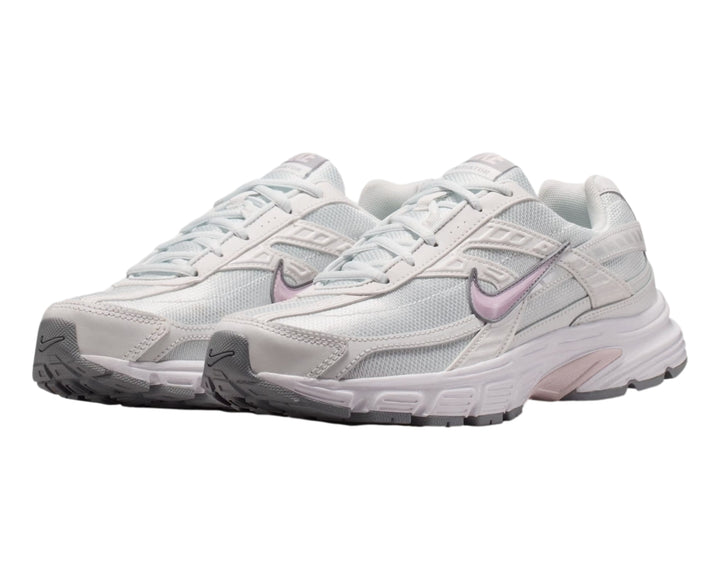 Tenis Nike Initiator blancos con detalles en color lila y suela gris, vista lateral.