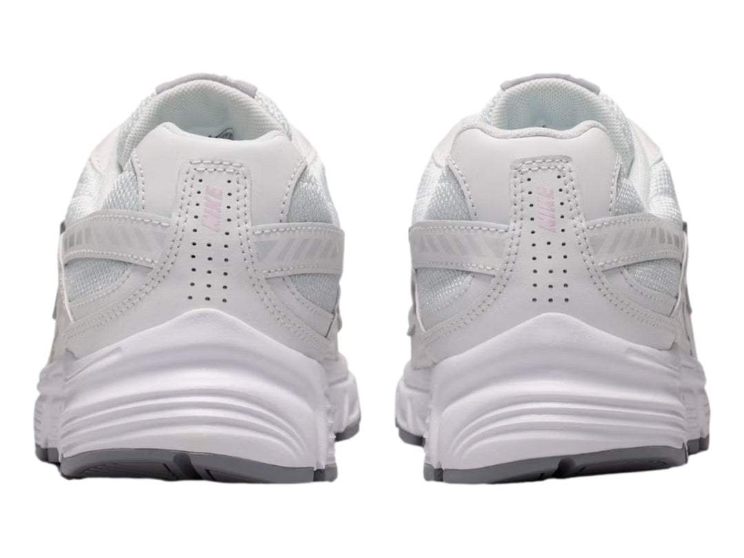 Tenis Nike Initiator blancos con detalles en color lila y suela gris, vista lateral.