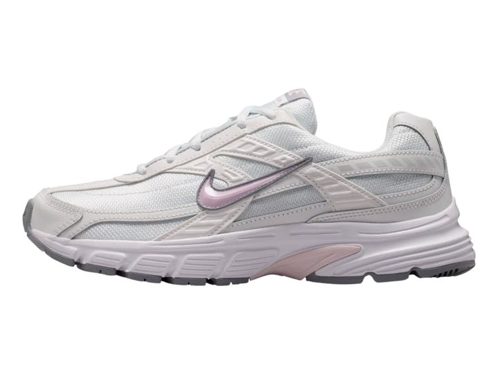 Tenis Nike Initiator blancos con detalles en color lila y suela gris, vista lateral.