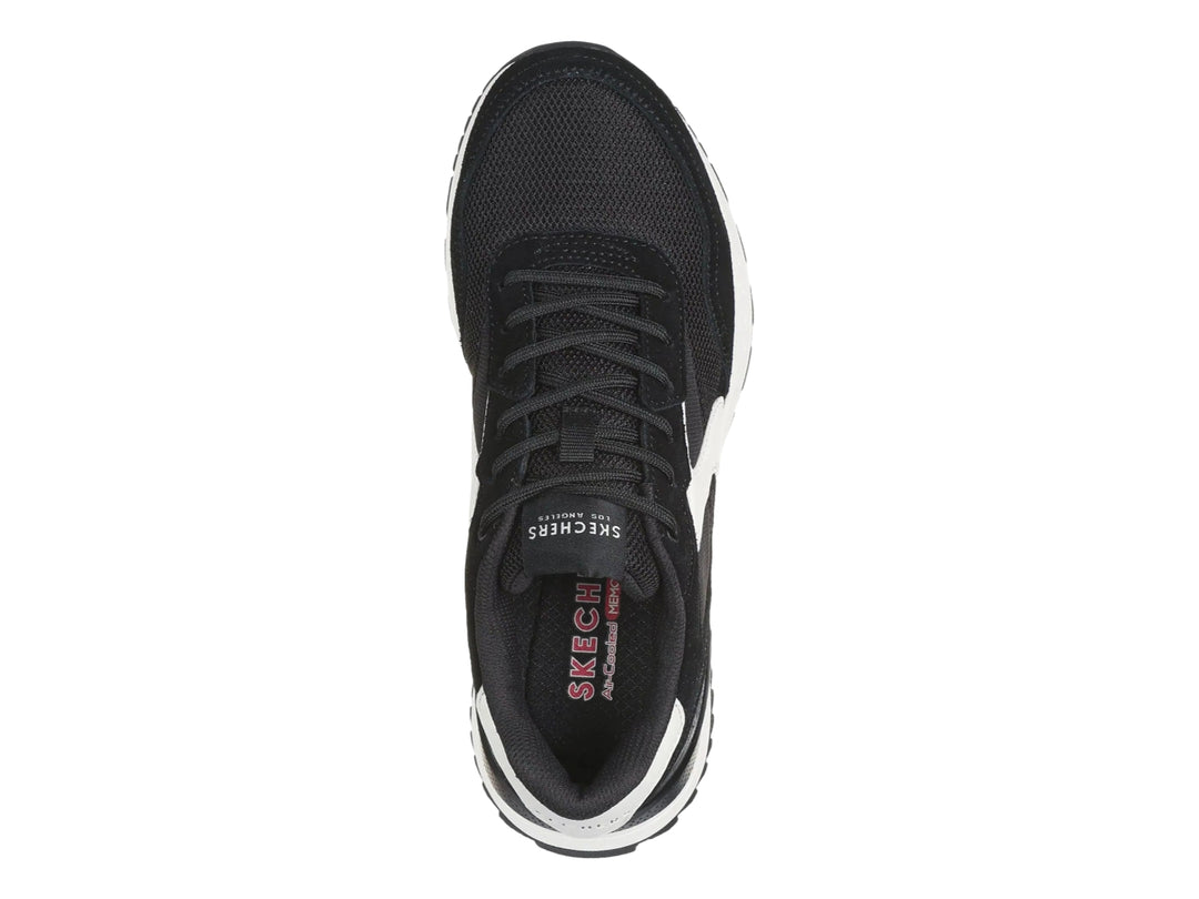 Tenis deportivos Skechers color negro con detalles y suela blanca.