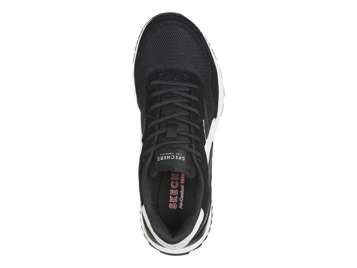 Tenis deportivos Skechers color negro con detalles y suela blanca.
