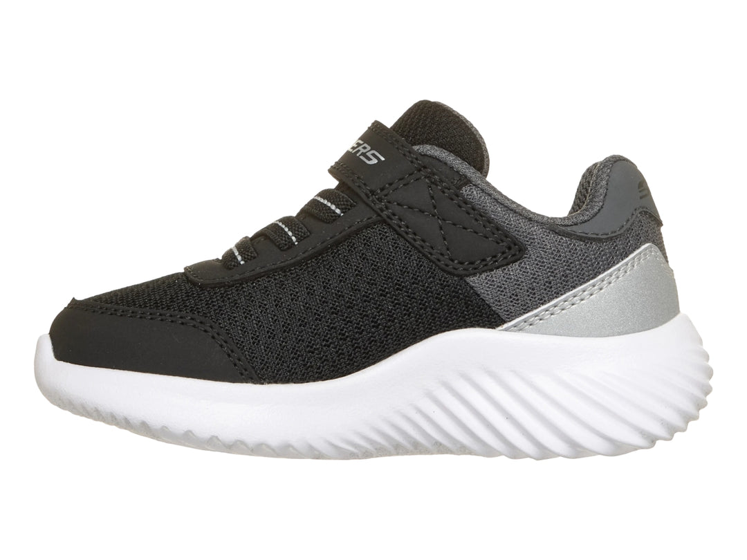 Tenis deportivos Skechers negros con suela blanca y detalle plateado en el talón.