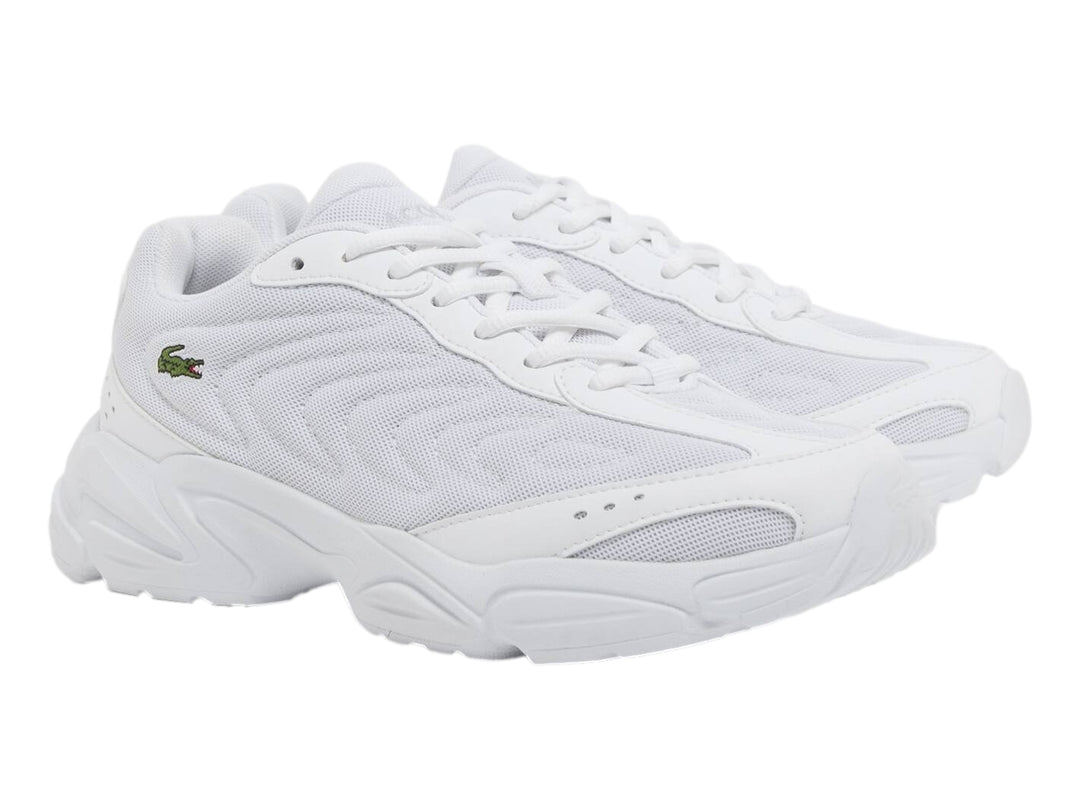Tenis Lacoste Storm 96 2K Lite blancos para junior con suela gruesa y logo de cocodrilo verde.