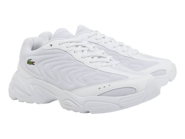 Tenis Lacoste Storm 96 2K Lite blancos para junior con suela gruesa y logo de cocodrilo verde.