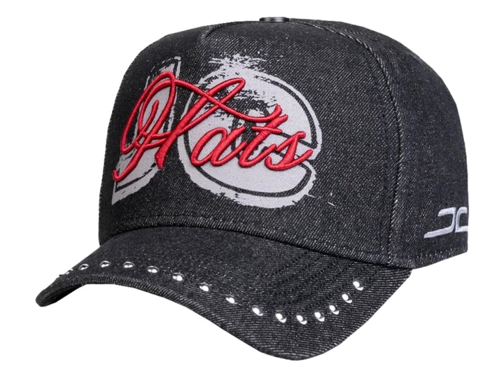 Gorra de mezclilla negra JC Hats con logo rojo bordado y tachuelas plateadas en la visera.
