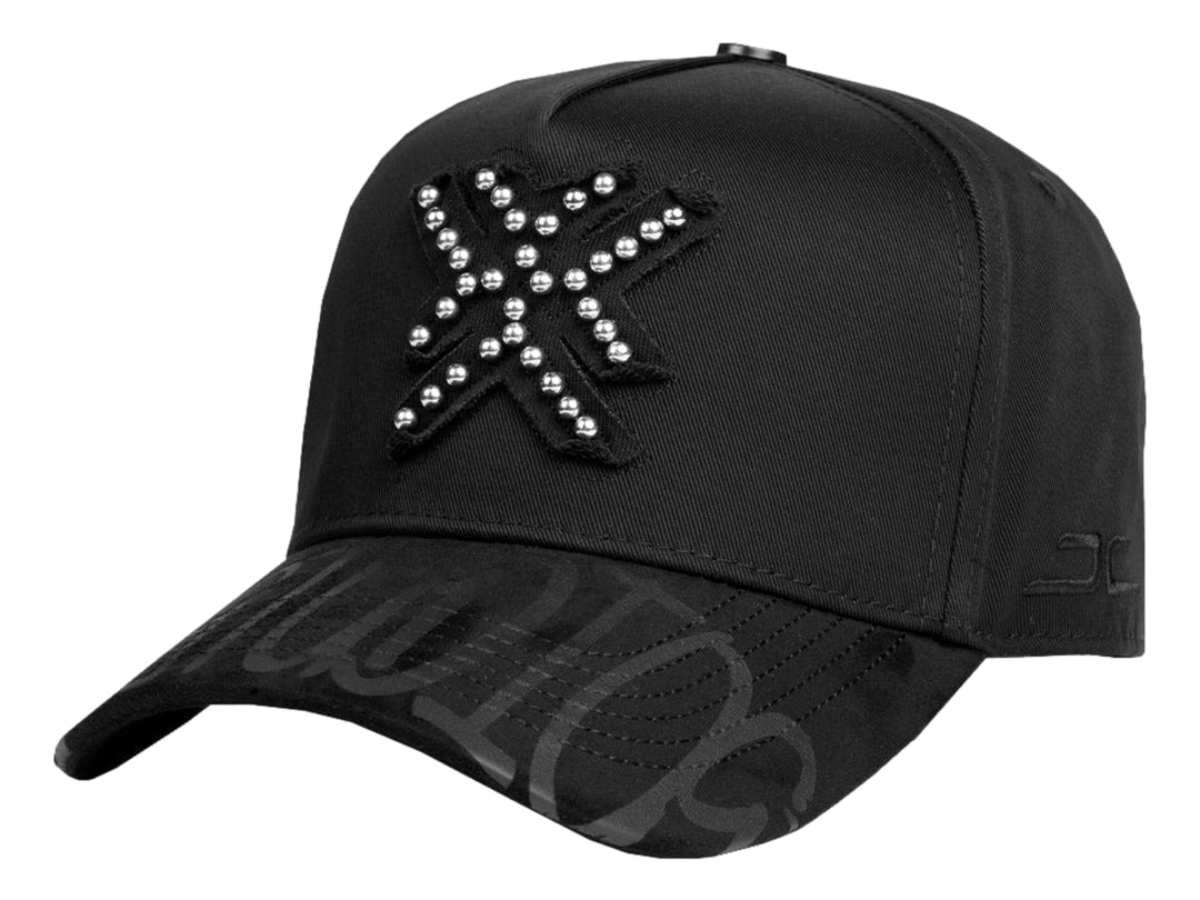 Gorra snapback negra con detalles de perlas plateadas en el frente y diseño gráfico en la visera.