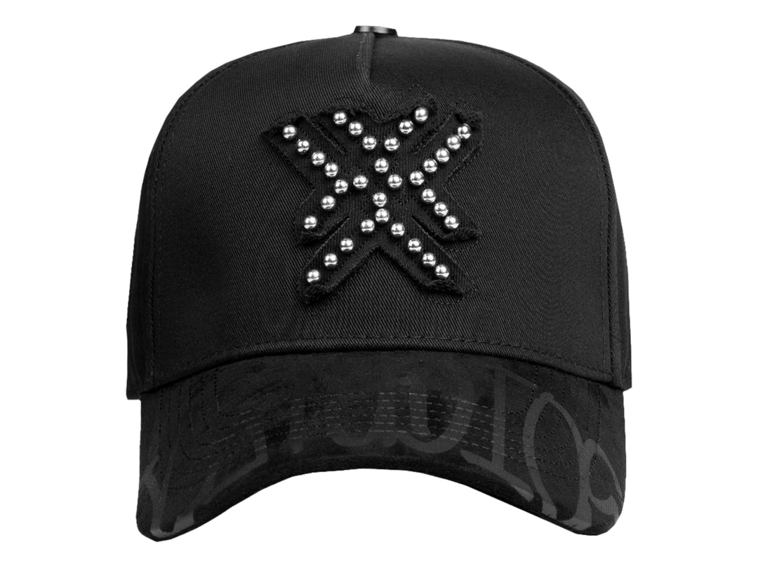 Gorra snapback negra con detalles de perlas plateadas en el frente y diseño gráfico en la visera.