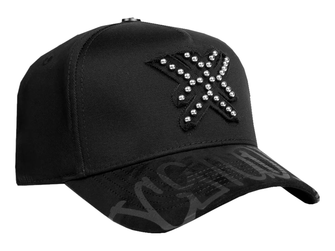 Gorra snapback negra con detalles de perlas plateadas en el frente y diseño gráfico en la visera.