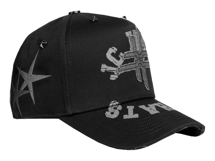 Gorra negra JC HATS con gráficos en gris y pequeños remaches metálicos en la parte superior.