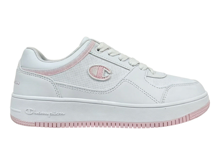 Tenis Champion blancos con detalles en color rosa en la suela y el cuello, diseño deportivo casual.