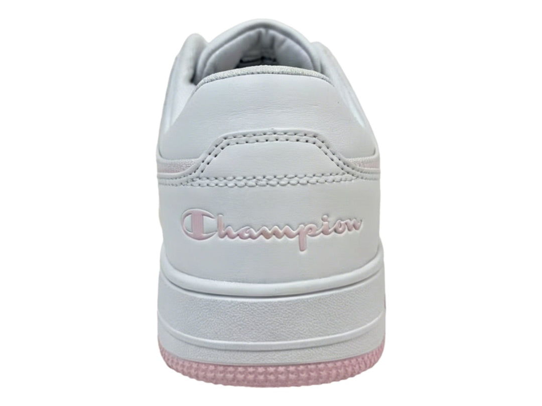 Tenis Champion blancos con detalles en color rosa en la suela y el cuello, diseño deportivo casual.