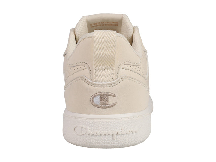 Tenis Champion Reverse en color beige con suela blanca y detalles perforados laterales.