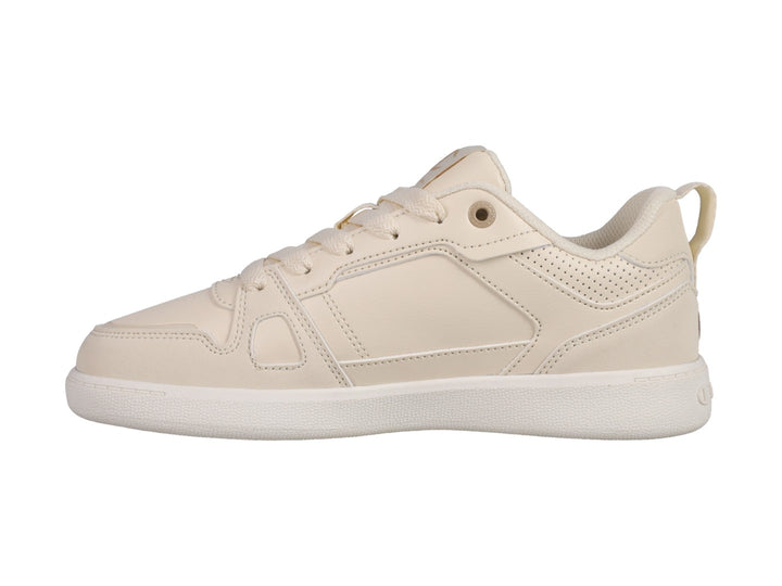 Tenis Champion Reverse en color beige con suela blanca y detalles perforados laterales.