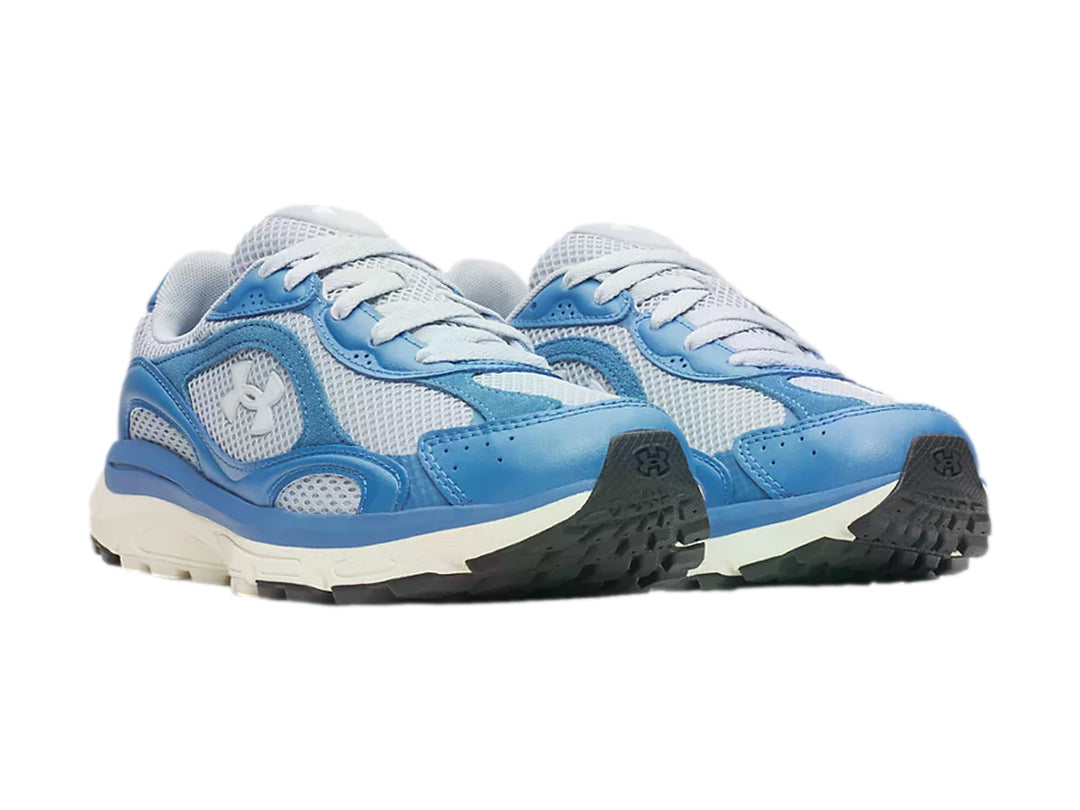 Tenis deportivos Under Armour en tonos azul y gris con suela blanca.