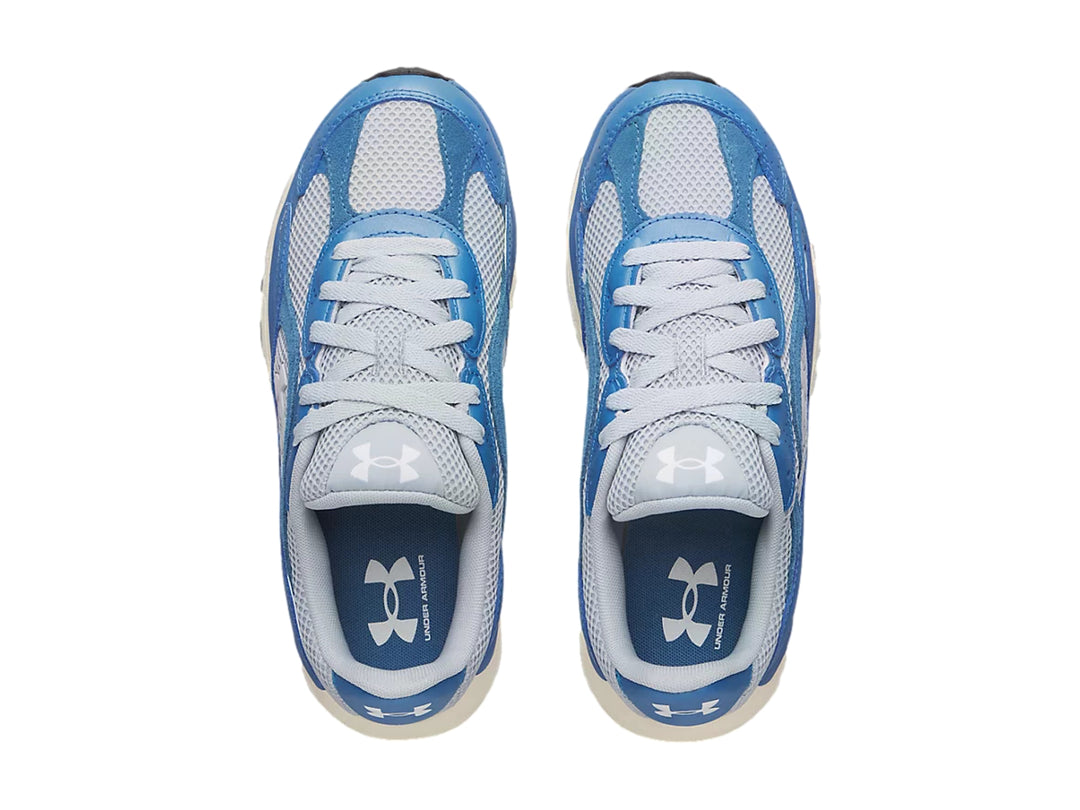 Tenis deportivos Under Armour en tonos azul y gris con suela blanca.