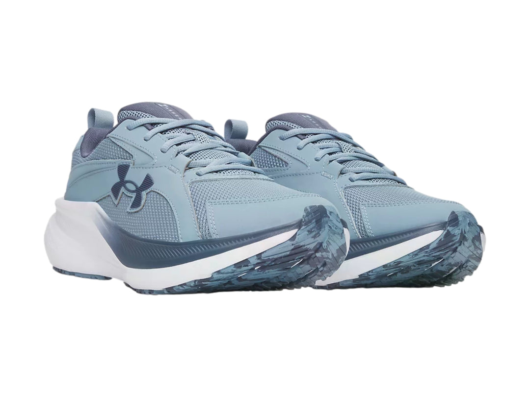 Tenis deportivos Under Armour color azul grisáceo con suela blanca, vista lateral.