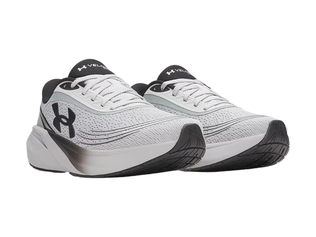 Tenis deportivos Under Armour color gris con detalles negros y suela blanca con degradado.