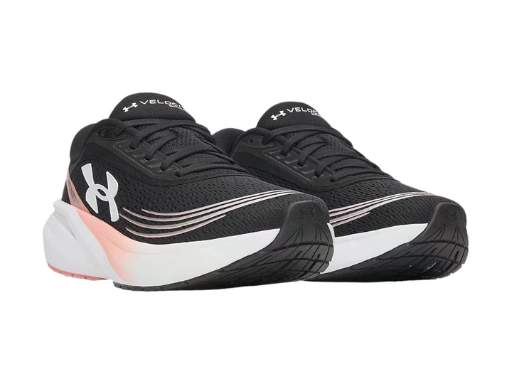 Tenis deportivos Under Armour color negro con suela blanca y detalles en rosa.