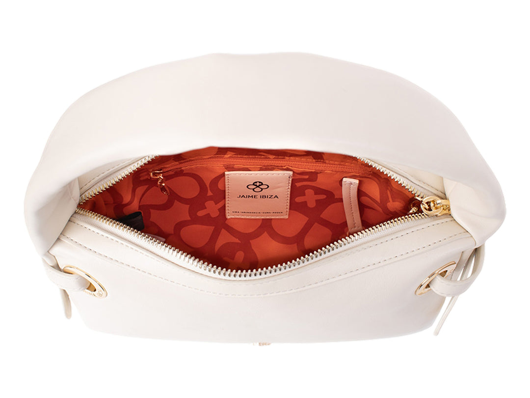 Bolsa de mano color beige de Jaime Ibiza con asa superior y detalles dorados.