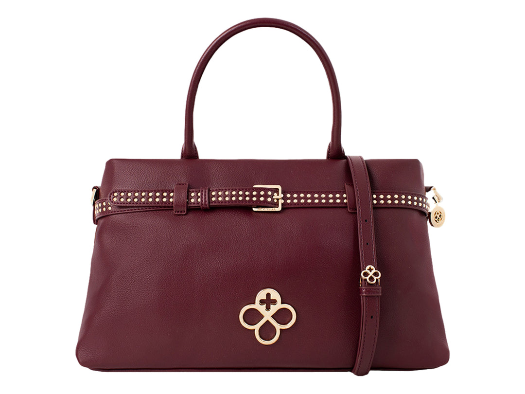 Bolsa de mano color burgundy con detalles dorados y textura de cuero granulado.