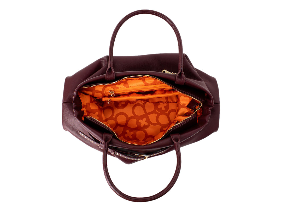 Bolsa de mano color burgundy con detalles dorados y textura de cuero granulado.
