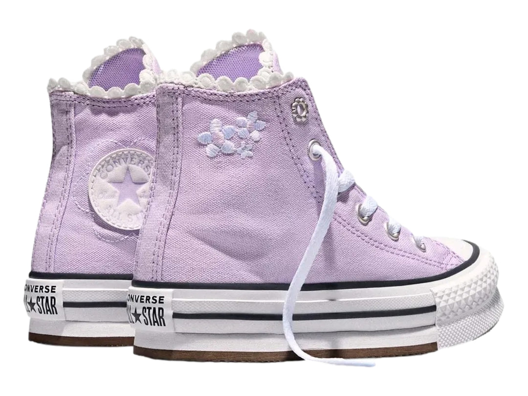 Tenis Converse de bota alta color lila con suela de plataforma blanca.