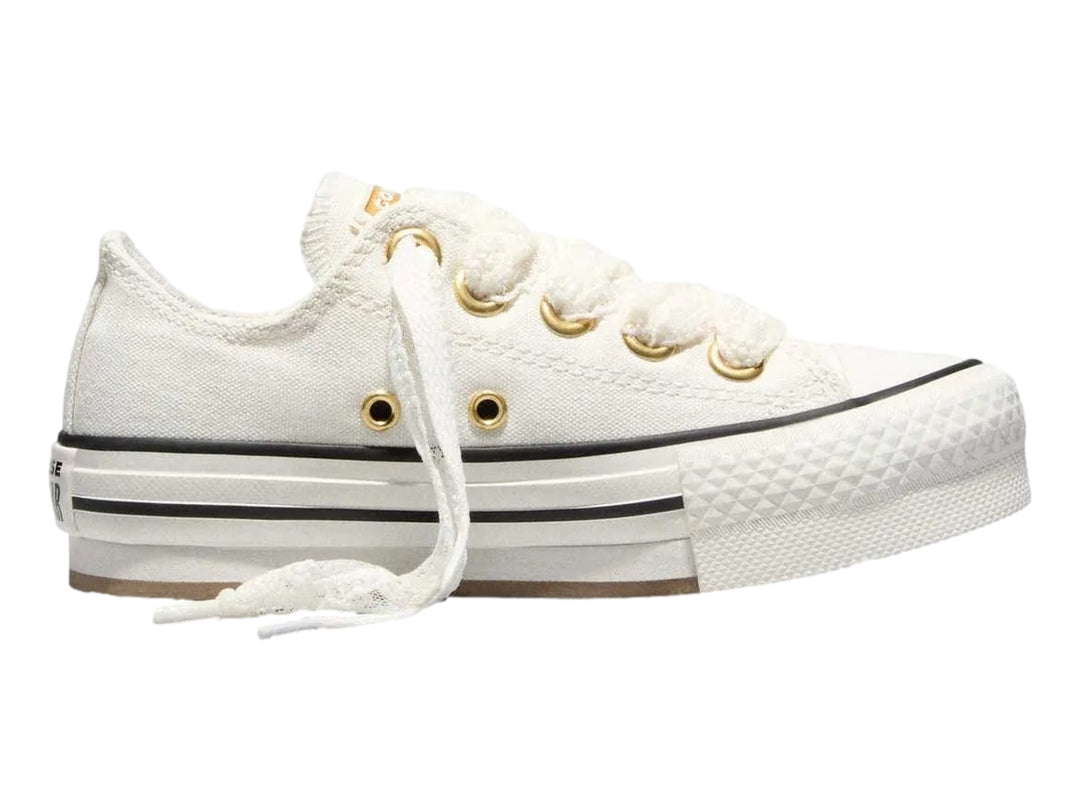 Tenis Converse Chuck Taylor All Star blancos de plataforma con ojillos dorados y suela gruesa.