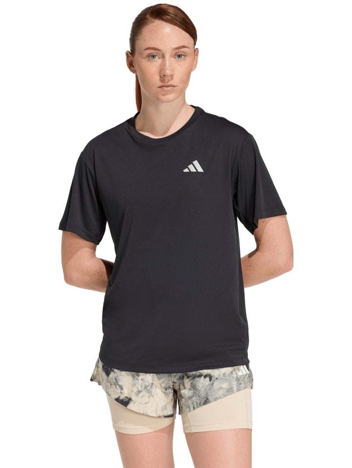 Mujer vistiendo playera deportiva Adidas de color negro con logo blanco en el pecho.