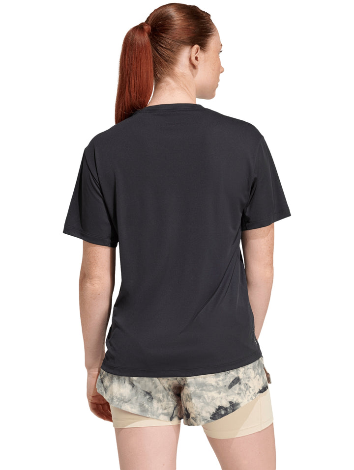Mujer vistiendo playera deportiva Adidas de color negro con logo blanco en el pecho.