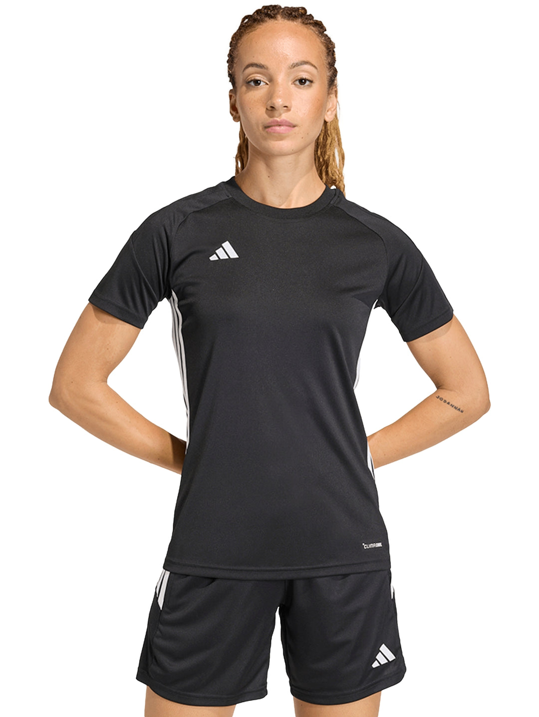 Mujer vistiendo playera deportiva Adidas de color negro con detalles blancos.