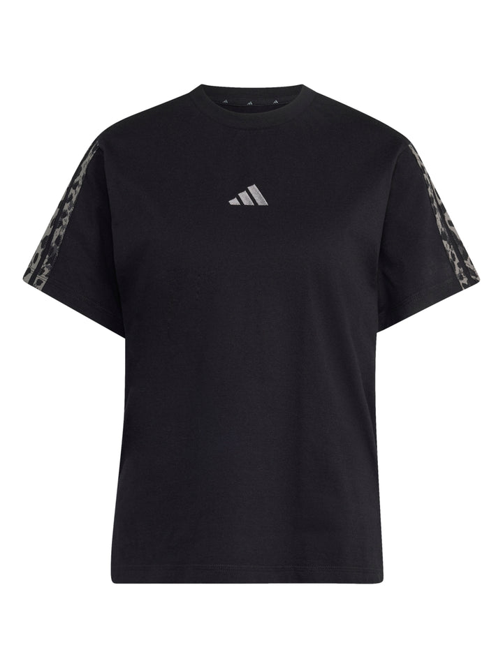 Mujer vistiendo playera deportiva Adidas color negro con estampado en las mangas.