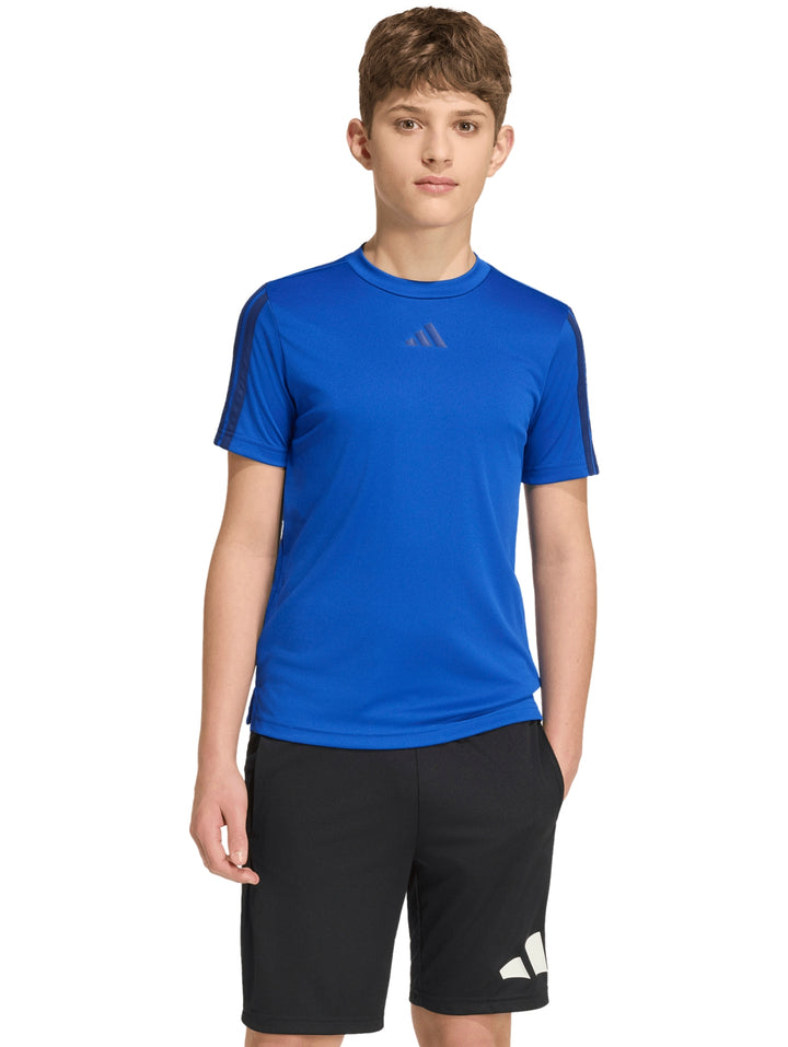Niño usando playera deportiva Adidas azul con rayas en hombros y shorts negros.