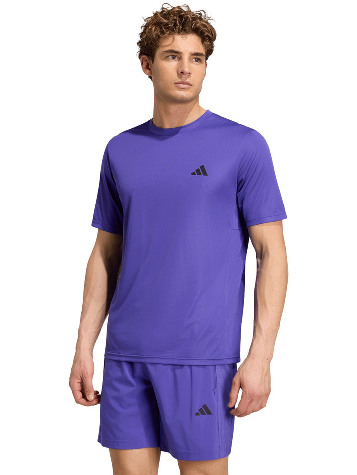 Hombre vistiendo playera y shorts deportivos de color púrpura de la marca Adidas.