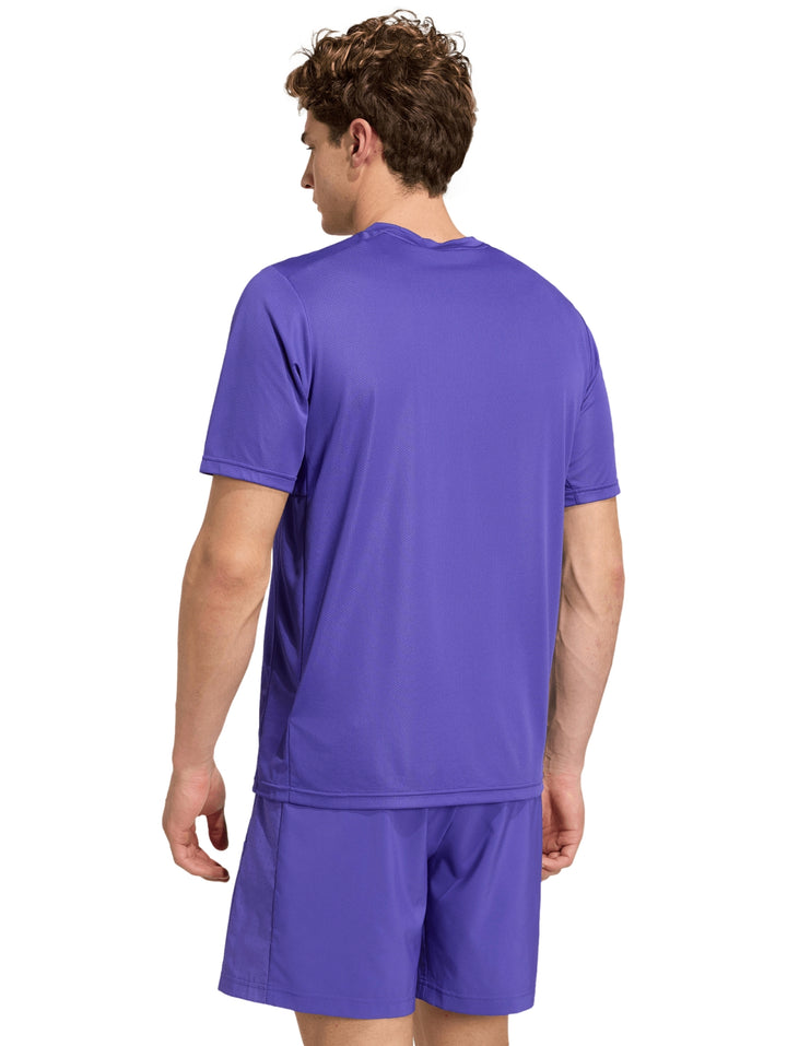 Hombre vistiendo playera y shorts deportivos de color púrpura de la marca Adidas.