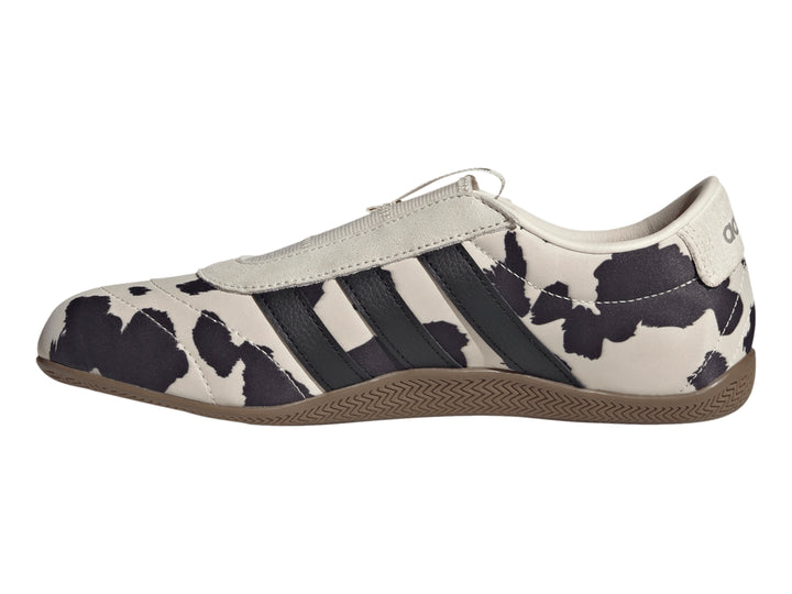 Tenis Adidas Grand Court Lo Slip con estampado de vaca en blanco y negro y suela color marrón.