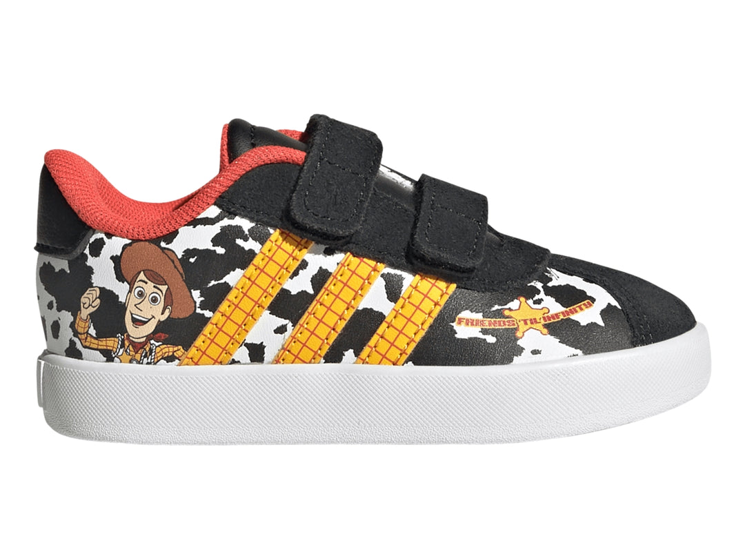 Tenis Adidas negros con estampado de vaca, rayas amarillas y personaje Woody de Toy Story.