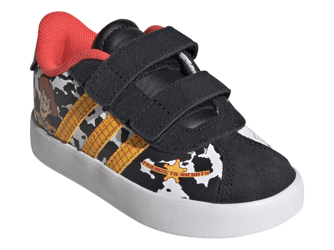 Tenis Adidas negros con estampado de vaca, rayas amarillas y personaje Woody de Toy Story.