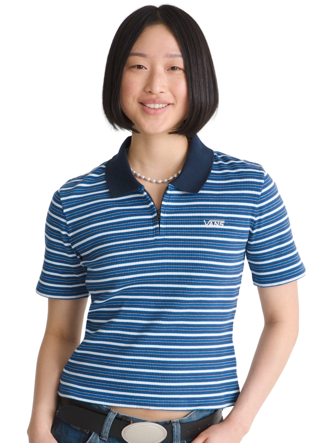 Mujer vistiendo playera polo Vans de rayas azules y blancas con cuello azul marino.