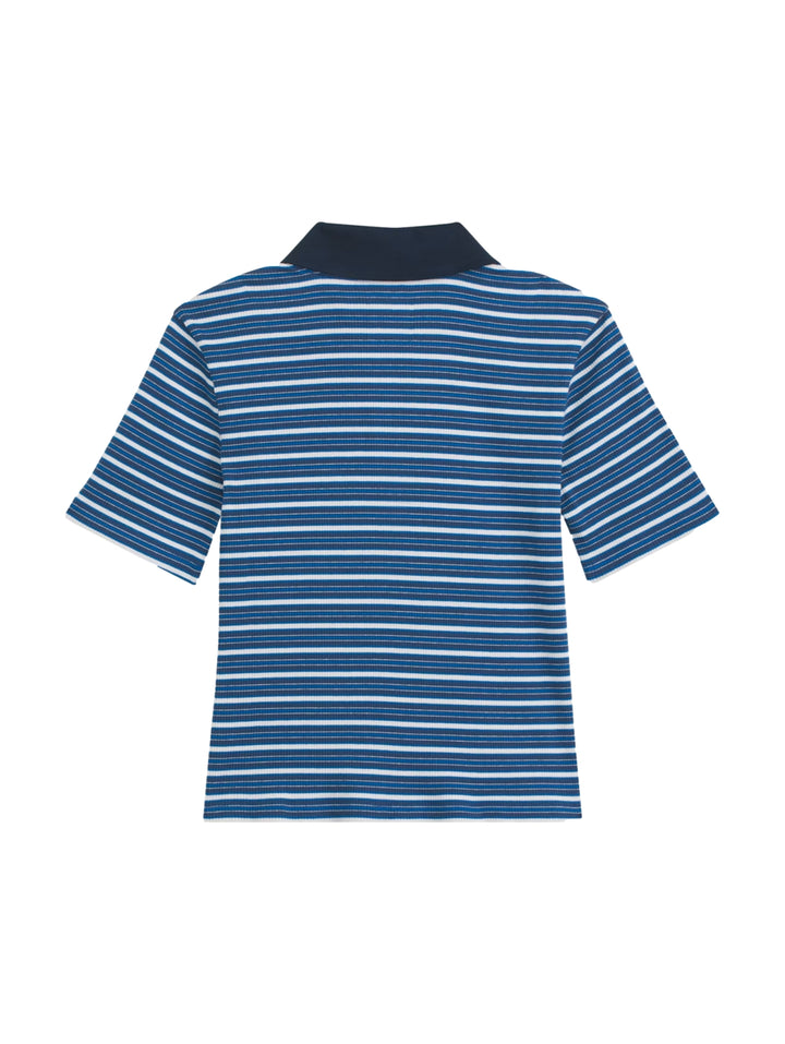Mujer vistiendo playera polo Vans de rayas azules y blancas con cuello azul marino.