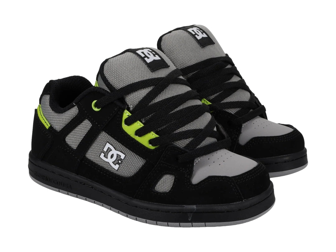 Tenis DC Shoes Stag color negro y gris con detalles en verde lima, vista lateral.