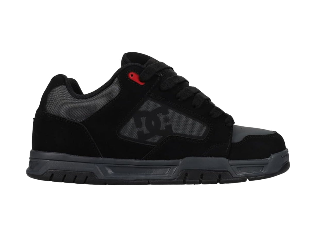 Tenis DC Shoes modelo Coiler en color negro y gris con un detalle rojo, vista lateral sobre fondo blanco.