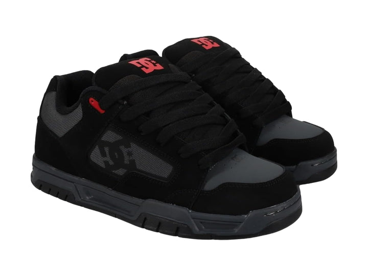 Tenis DC Shoes modelo Coiler en color negro y gris con un detalle rojo, vista lateral sobre fondo blanco.