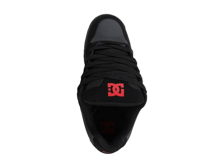 Tenis DC Shoes modelo Coiler en color negro y gris con un detalle rojo, vista lateral sobre fondo blanco.