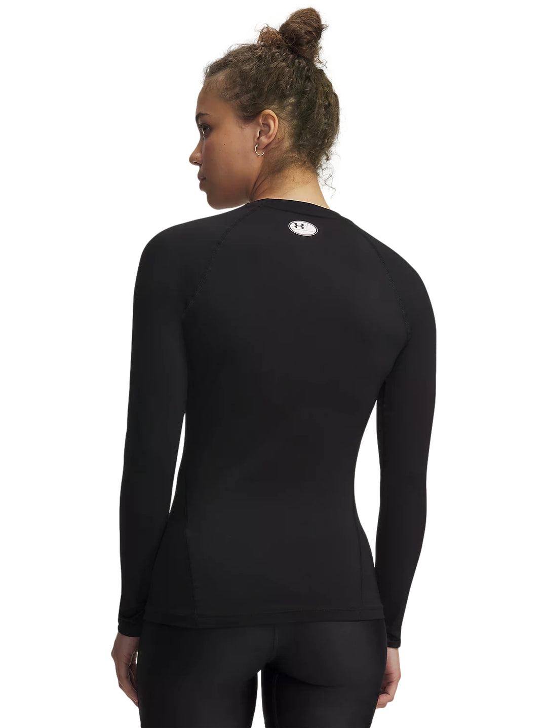 Mujer vistiendo playera deportiva negra de manga larga Under Armour HeatGear.