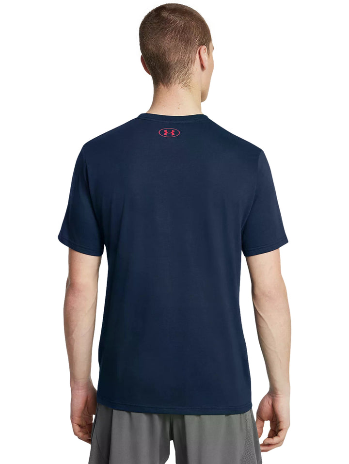 Hombre vistiendo playera deportiva Under Armour color azul marino con logotipo frontal en blanco y rojo.