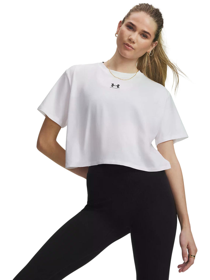 Mujer vistiendo playera blanca Under Armour Rival Boxy Tee de corte amplio y manga corta.
