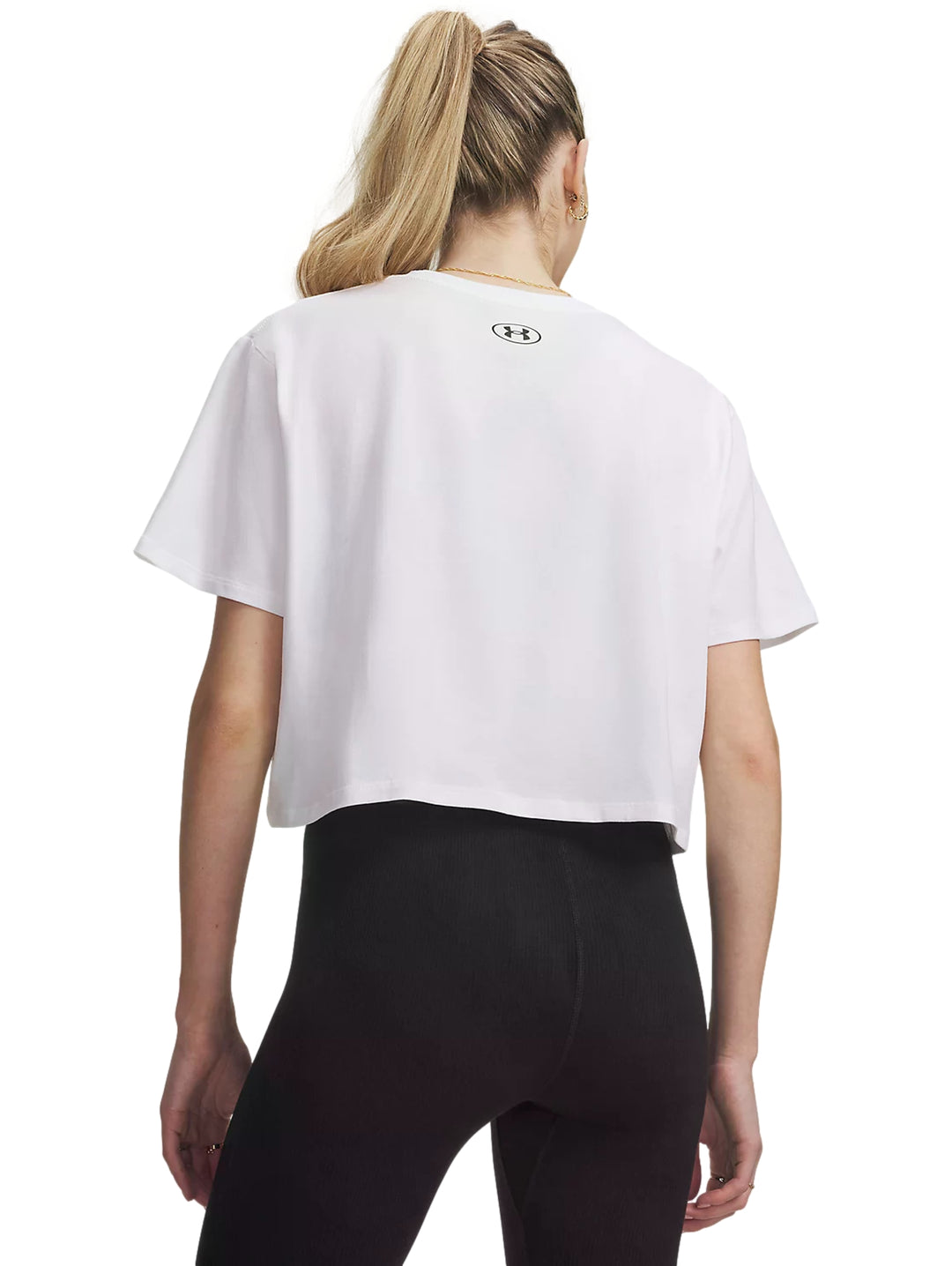 Mujer vistiendo playera blanca Under Armour Rival Boxy Tee de corte amplio y manga corta.