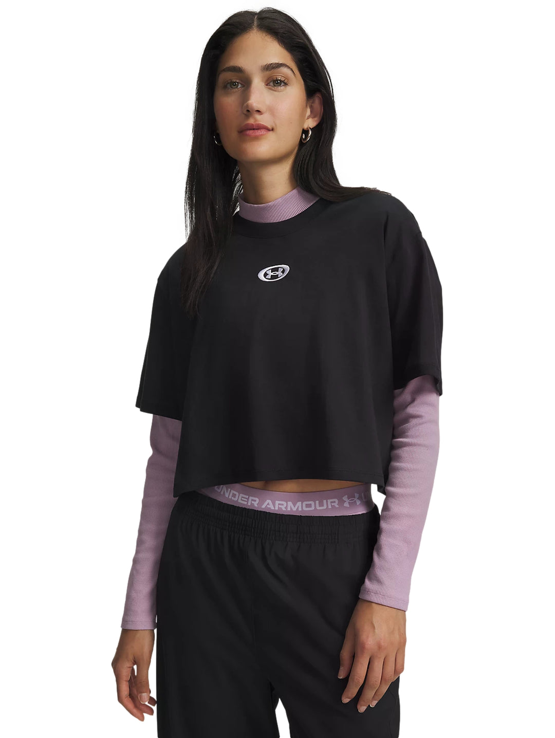Mujer vistiendo playera deportiva negra de manga corta Under Armour sobre una prenda morada.