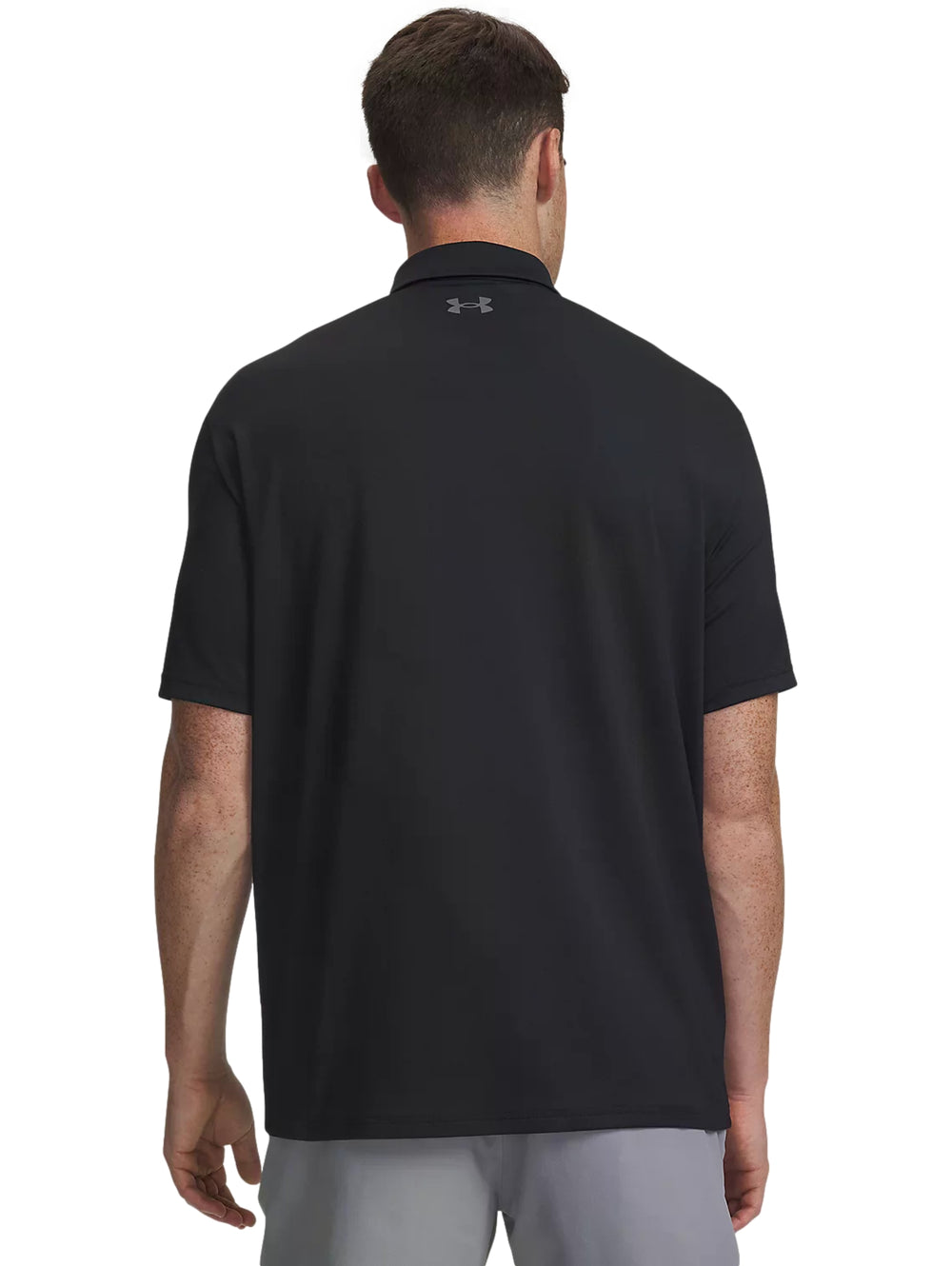 Hombre vistiendo playera polo Under Armour color negro de manga corta.
